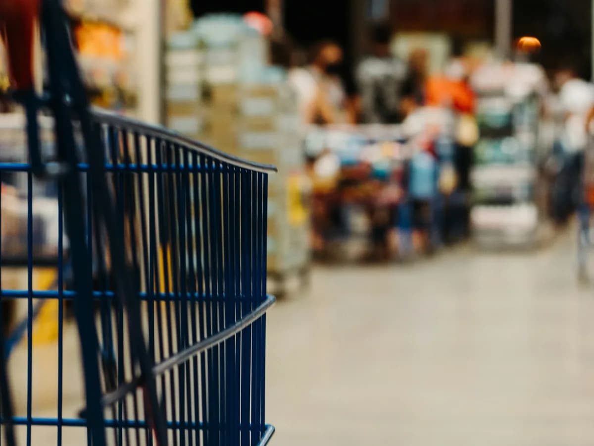 Carrinho azul no corredor de um supermercado.