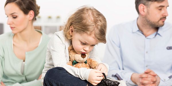 menina segurando um cachorrinho de pelúcia com os pais olhando em direções opostas tratando sobre guarda compartilhada e pensão alimentícia